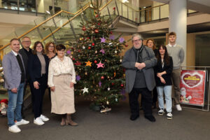 Schmückten den Wunschbaum mit 100 Kinderwünschen: Robert Huber (v.l.), Sven Stampe, Laura Pütz, Sabine Gilles-Falkenstein, Antje Ibendorf (alle KSK), Bernd Kolvenbach (Kinderschutzbund), Melanie Schwarzhoff (KSK), Lena Wefers (Kinderschutzbund) und Daniel Rudovac (KSK). Bild: Michael Thalken/Eifeler Presse Agentur/epa 