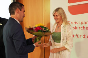 Sebastian Thur überreicht einen Blumenstrauß an Susanne Donicht. Bild: Michael Thalken/Eifeler Presse Agentur/epa