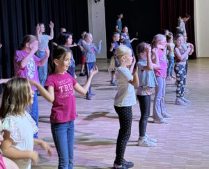 Beim Abschlussfest im Forum Zülpich gaben die Mädchen und Jungen der diesjährigen Stadtranderholung den zuvor gemeinsam einstudierten Tanz zu den Klängen des Partyschlagers „Wackelkontakt“ zum Besten. Bild: Torsten Beulen/Stadt Zülpich