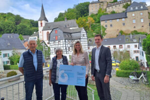 Roman Sohnius (Kreissparkasse Euskirchen) (v.r.) und die Bürgermeisterin der Gemeinde Blankenheim, Jennifer Meuren, übergaben den ersten Preis des Tour-de-Ahrtal-Gewinnspiels an Beate Nelles aus Schuld, die mit ihrem Mann angereist war. Bild: Gemeinde Blankenheim