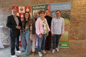 Zogen Bilanz und stellten die weiteren Vorhaben des Mundart-Projekts vor: KSK-Vorstandsvorsitzender Udo Becker (v.l.), Projektmanagerin Annika Esch, die Leiterin des Kulturhofs Velbrück, Marietta Thien, Carla Neisse-Hommelsheim (Vorsitzende der LAG Zülpicher Börde), Marie Marx (Ko-Regionalmanagerin LAG) und Sebastian Duif (Regionalmanager LAG). Bild: Michael Thalken/Eifeler Presse Agentur/epa