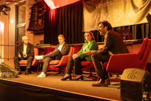 Voll des Lobes und mit reichlich Anekdoten versehen berichteten Holger Glück (v.l.), Vorstandsvorsitzender KSK, Landrat Markus Ramers und Saskia Lagemann, Geschäftsführerin Rheinischer Sparkassen- und Giroverband, dem Moderator Sebastian Tittelbach ihre Erlebnisse mit dem scheidenden Udo Becker. Bild: Tameer Gunnar Eden/Eifeler Presse Agentur/epa