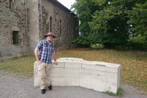 Der Autor und Lokalhistoriker Andreas Züll vor der Kirche und dem Dorfmodell in Wollseifen. Bild: Andreas Züll
